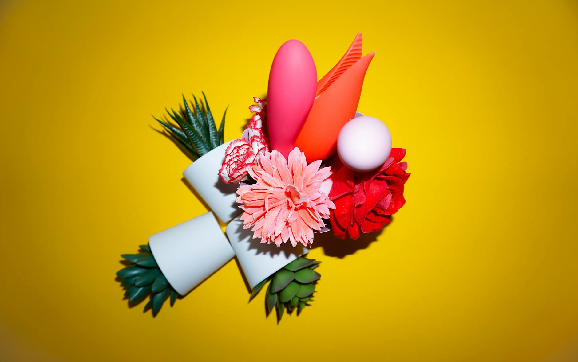 Yellow silicone lemon clitoral vibrator surrounded by fresh lemons on a bright yellow background